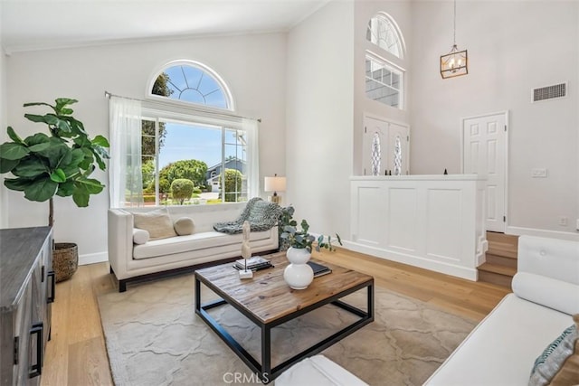 9 Phillips Cir, Laguna Niguel, CA 92677 - living area featuring healthy amount of natural light, light wood-style floors, a high ceiling, and a chandelier