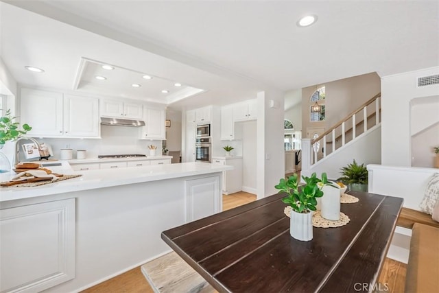 9 Phillips Cir, Laguna Niguel, CA 92677 - dining area featuring a tray ceiling, recessed lighting, stairway, and light wood-type flooring