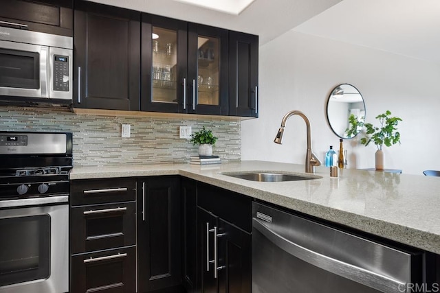 183 Mangano Cir, Encinitas, CA 92024 - kitchen with appliances with stainless steel finishes, light stone countertops, decorative backsplash, and glass insert cabinets