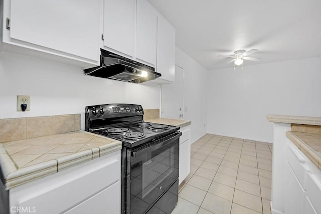 23515 Lyons Ave Unit 140, Valencia, CA 91355 - kitchen with electric range, under cabinet range hood, a ceiling fan, light tile patterned floors, and white cabinetry
