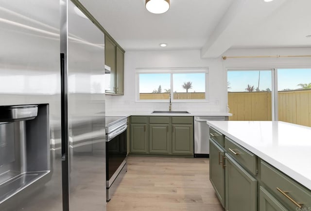 615 Fredricks Ave Unit 157, Oceanside, CA 92058 - kitchen with stainless steel appliances, green cabinetry, plenty of natural light, decorative backsplash, and recessed lighting