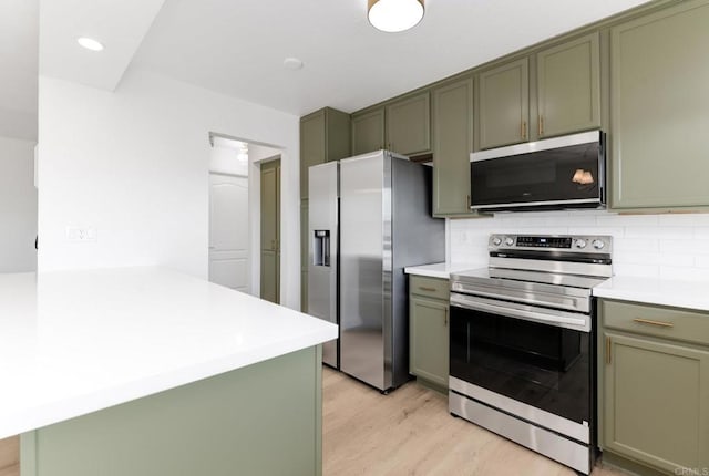 615 Fredricks Ave Unit 157, Oceanside, CA 92058 - kitchen featuring stainless steel appliances, green cabinets, light wood-style flooring, light countertops, and recessed lighting