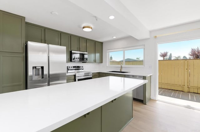 615 Fredricks Ave Unit 157, Oceanside, CA 92058 - kitchen featuring appliances with stainless steel finishes, green cabinets, decorative backsplash, light countertops, and recessed lighting