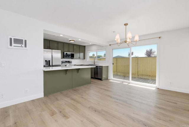 615 Fredricks Ave Unit 157, Oceanside, CA 92058 - kitchen with stainless steel appliances, a chandelier, light countertops, a breakfast bar, and light wood finished floors