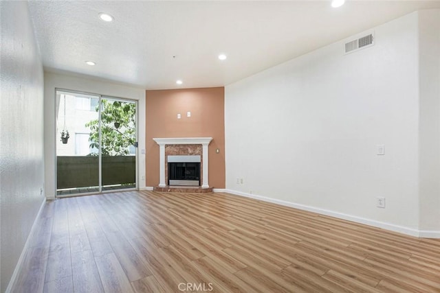 16940 Chatsworth St Unit 208, Granada Hills, CA 91344 - unfurnished living room with light wood-style floors, recessed lighting, and a premium fireplace