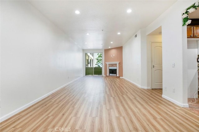 16940 Chatsworth St Unit 208, Granada Hills, CA 91344 - unfurnished living room featuring recessed lighting, light wood-style flooring, and a fireplace