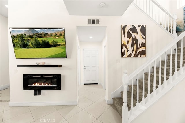 11209 Pinecone St, Corona, CA 92883 - staircase featuring a glass covered fireplace, tile patterned floors, and recessed lighting