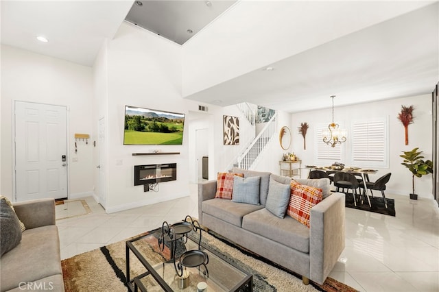 11209 Pinecone St, Corona, CA 92883 - living area with stairs, a glass covered fireplace, light tile patterned floors, a chandelier, and a towering ceiling