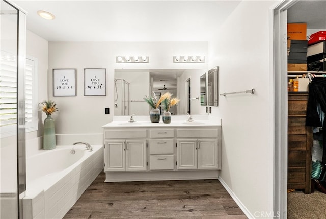 11209 Pinecone St, Corona, CA 92883 - full bathroom featuring double vanity, a bath, wood finished floors, a shower with shower door, and a walk in closet
