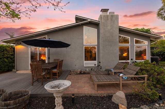 764 E Solana Cir, Solana Beach, CA 92075 - back of property at dusk with a chimney, stucco siding, a wooden deck, outdoor dining space, and a patio