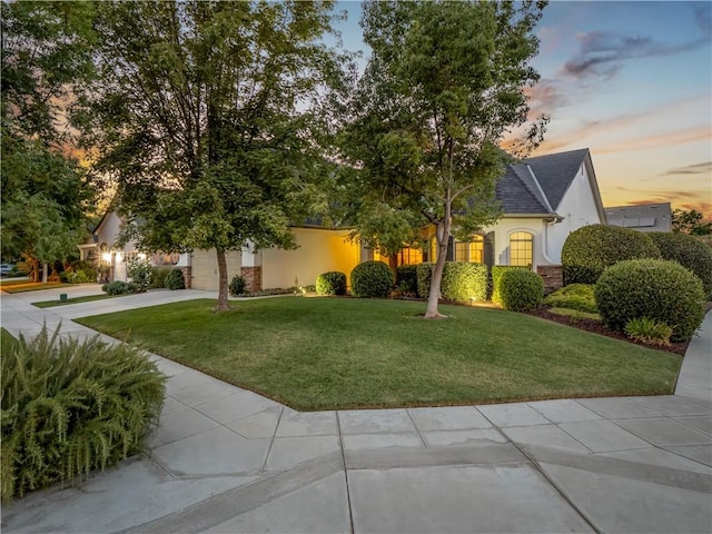 425 W Trenton Ave, Clovis, CA 93619 - obstructed view of property with concrete driveway, stucco siding, a front lawn, an attached garage, and roof with shingles