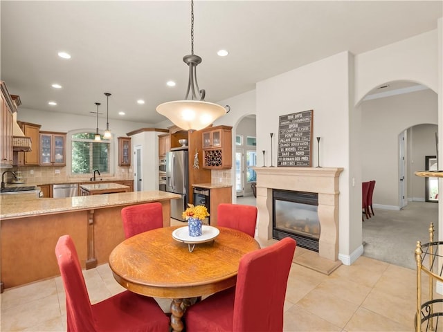 425 W Trenton Ave, Clovis, CA 93619 - dining area with arched walkways, recessed lighting, a glass covered fireplace, light tile patterned floors, and beverage cooler