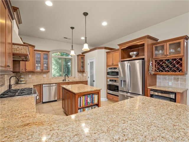 425 W Trenton Ave, Clovis, CA 93619 - kitchen with stainless steel appliances, open shelves, backsplash, light stone countertops, and brown cabinetry
