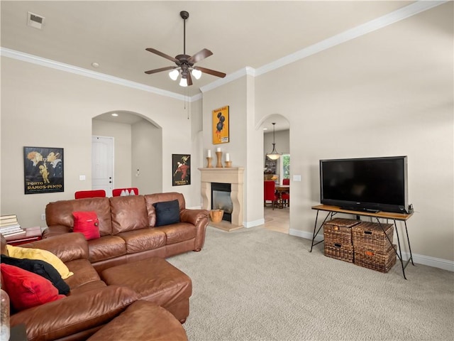 425 W Trenton Ave, Clovis, CA 93619 - carpeted living room featuring arched walkways, a ceiling fan, ornamental molding, and a glass covered fireplace