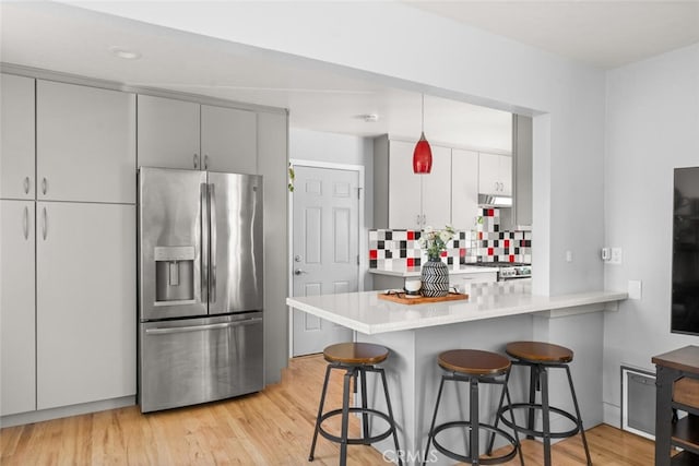 571 Redwood Way, Chico, CA 95926 - kitchen featuring stainless steel refrigerator with ice dispenser, a peninsula, light wood-type flooring, and a breakfast bar