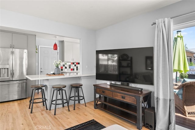 571 Redwood Way, Chico, CA 95926 - kitchen with stainless steel fridge, light wood-style floors, a kitchen breakfast bar, and a peninsula