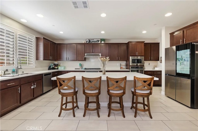 9574 Alta Cresta Ave, Riverside, CA 92508 - kitchen featuring stainless steel appliances, light countertops, a breakfast bar area, a kitchen island, and recessed lighting