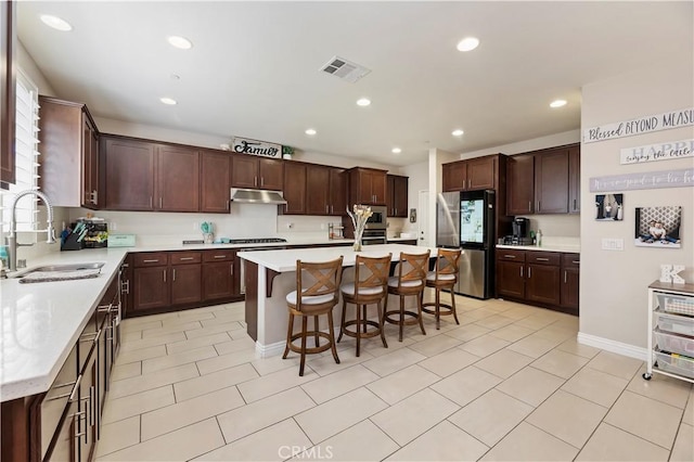 9574 Alta Cresta Ave, Riverside, CA 92508 - kitchen featuring stainless steel appliances, under cabinet range hood, a breakfast bar area, an island with sink, and recessed lighting