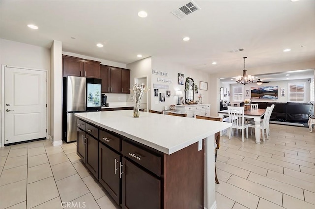 9574 Alta Cresta Ave, Riverside, CA 92508 - kitchen featuring freestanding refrigerator, a chandelier, open floor plan, dark brown cabinets, and light countertops