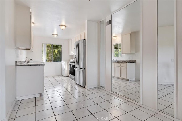 29788 Sea Shore Ln Unit 30, Laguna Niguel, CA 92677 - kitchen with appliances with stainless steel finishes, light tile patterned floors, white cabinets, and dark stone counters