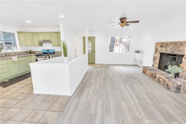 26188 Boulder Ln, Twin Peaks, CA 92391 - kitchen with stainless steel range with gas cooktop, under cabinet range hood, a fireplace, light countertops, and a ceiling fan