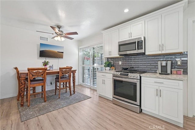 3126 E Merrygrove St, West Covina, CA 91792 - kitchen with appliances with stainless steel finishes, light wood-type flooring, tasteful backsplash, white cabinets, and ceiling fan