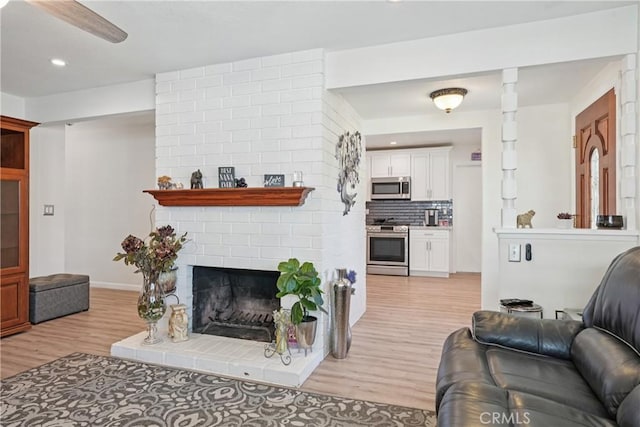3126 E Merrygrove St, West Covina, CA 91792 - living room featuring light wood-type flooring, recessed lighting, and a brick fireplace