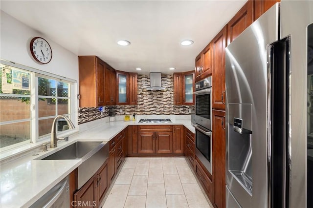 8303 Topeka Dr, Northridge, CA 91324 - kitchen featuring appliances with stainless steel finishes, wall chimney range hood, tasteful backsplash, light tile patterned floors, and glass insert cabinets