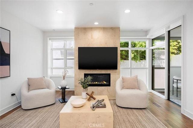 447 N Doheny Dr Unit 104, Beverly Hills, CA 90210 - living area featuring a tiled fireplace, wood finished floors, plenty of natural light, and recessed lighting