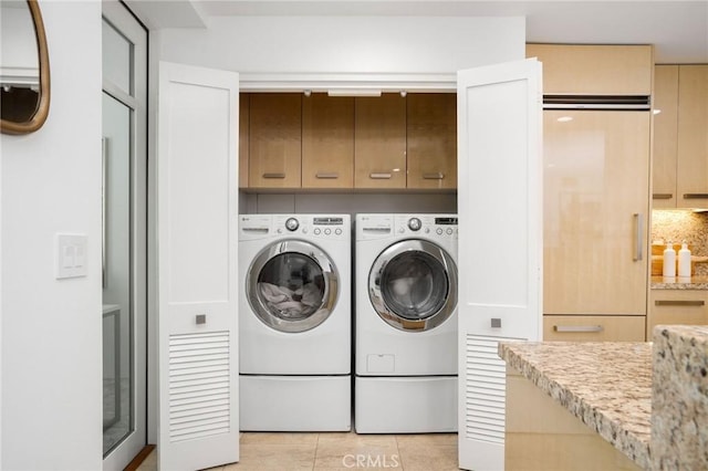 447 N Doheny Dr Unit 104, Beverly Hills, CA 90210 - laundry area featuring washer and dryer, cabinet space, and light tile patterned floors