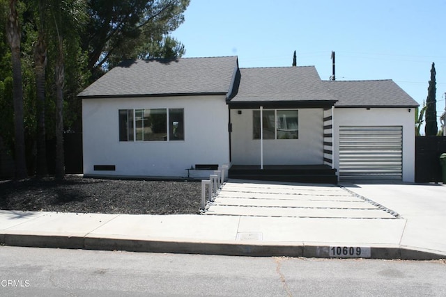 10609 Fernglen Ave, Tujunga, CA 91042 - view of front of house featuring a garage, driveway, covered porch, and a shingled roof