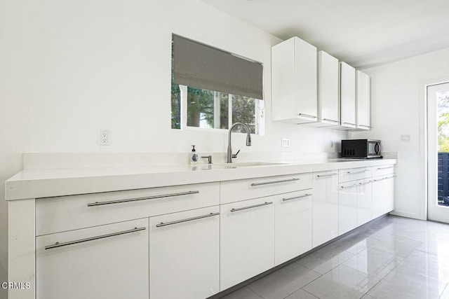 10609 Fernglen Ave, Tujunga, CA 91042 - kitchen with healthy amount of natural light, white cabinetry, and light countertops