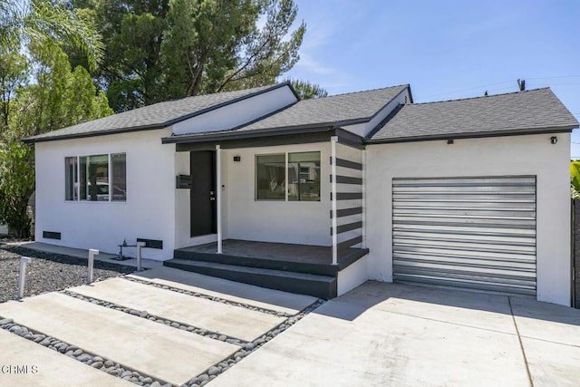 10609 Fernglen Ave, Tujunga, CA 91042 - view of front of house with concrete driveway, a shingled roof, a garage, and stucco siding