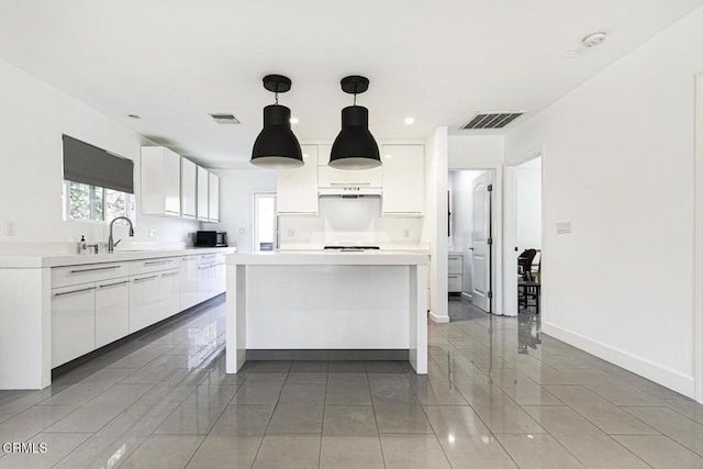 10609 Fernglen Ave, Tujunga, CA 91042 - kitchen featuring white cabinetry, light countertops, a kitchen island, hanging light fixtures, and light tile patterned flooring