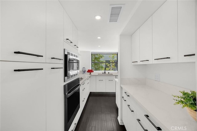 11601 Montana Ave Unit 7, Los Angeles, CA 90049 - kitchen featuring stainless steel microwave, oven, light countertops, recessed lighting, and white cabinets
