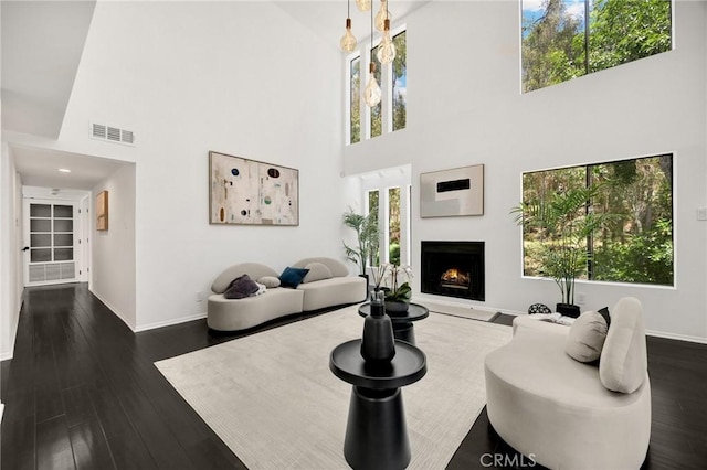 11601 Montana Ave Unit 7, Los Angeles, CA 90049 - living room featuring a high ceiling, plenty of natural light, a lit fireplace, and wood finished floors