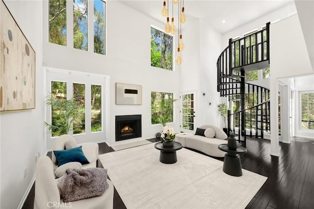 11601 Montana Ave Unit 7, Los Angeles, CA 90049 - living area featuring stairs, a high ceiling, plenty of natural light, a lit fireplace, and dark wood-type flooring