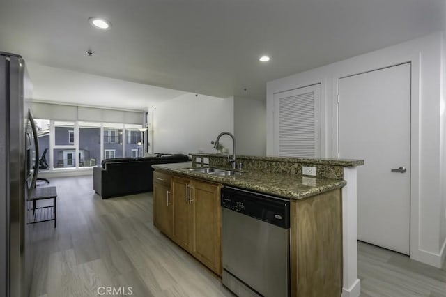 411 W Seaside Way Unit 402, Long Beach, CA 90802 - kitchen featuring stainless steel appliances, light wood finished floors, dark stone countertops, an island with sink, and open floor plan