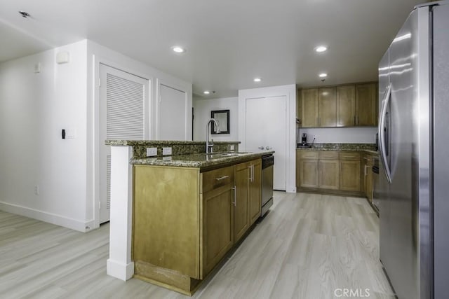 411 W Seaside Way Unit 402, Long Beach, CA 90802 - kitchen featuring stainless steel appliances, light wood-style flooring, dark stone countertops, an island with sink, and recessed lighting