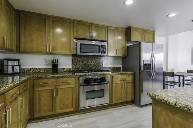 411 W Seaside Way Unit 402, Long Beach, CA 90802 - kitchen featuring stainless steel appliances, dark stone countertops, brown cabinetry, and recessed lighting