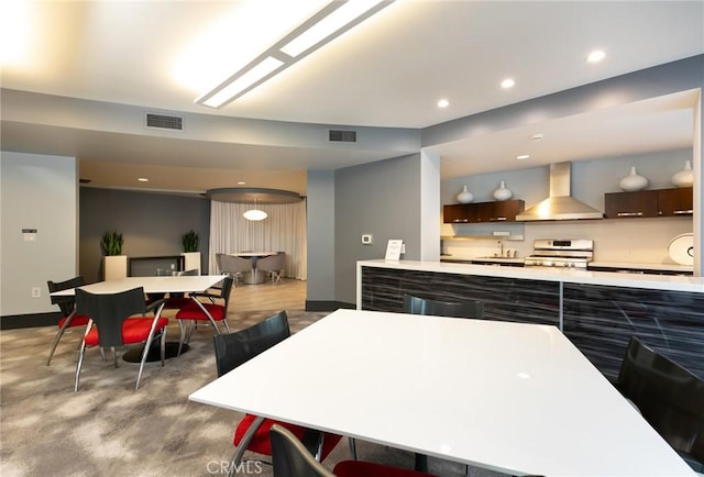411 W Seaside Way Unit 402, Long Beach, CA 90802 - kitchen featuring wall chimney range hood, gas range oven, light countertops, recessed lighting, and dark brown cabinets
