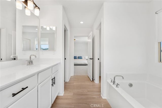 32886 Birchall Ct, Winchester, CA 92596 - bathroom with vanity, ensuite bath, wood finished floors, a garden tub, and recessed lighting