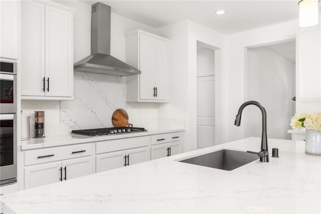32886 Birchall Ct, Winchester, CA 92596 - kitchen with wall chimney range hood, appliances with stainless steel finishes, light stone countertops, white cabinetry, and recessed lighting