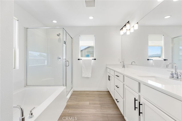 32886 Birchall Ct, Winchester, CA 92596 - bathroom featuring double vanity, a stall shower, a garden tub, wood finished floors, and recessed lighting