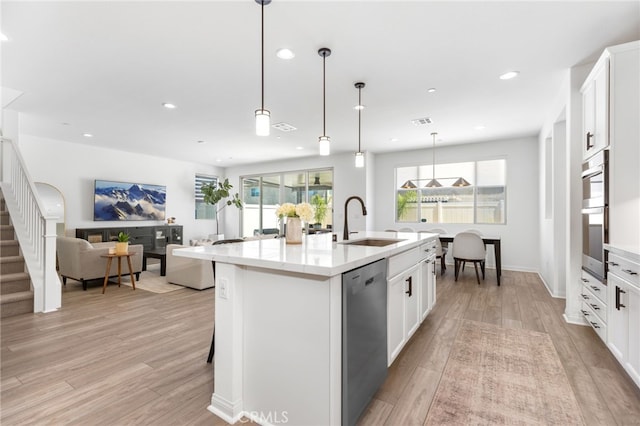 32886 Birchall Ct, Winchester, CA 92596 - kitchen featuring appliances with stainless steel finishes, light wood-style flooring, a kitchen island with sink, white cabinets, and recessed lighting