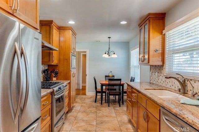 923 Farroll Ave, Arroyo Grande, CA 93420 - kitchen with appliances with stainless steel finishes, brown cabinetry, tasteful backsplash, glass insert cabinets, and light stone countertops
