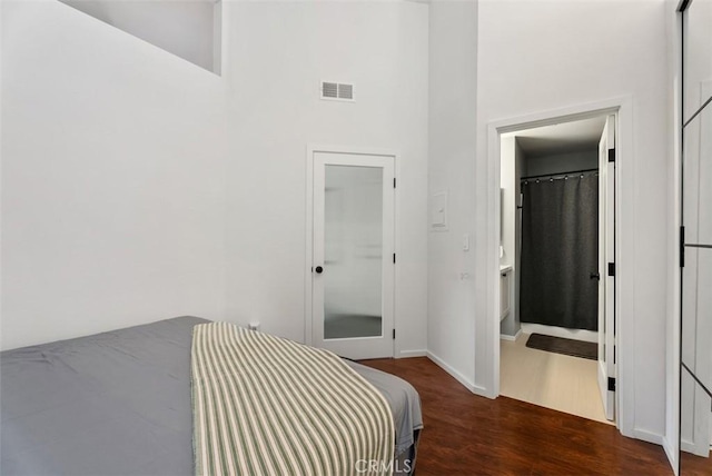 1046 Calle Del Cerro Unit 408, San Clemente, CA 92672 - bedroom with a high ceiling, wood finished floors, and ensuite bathroom