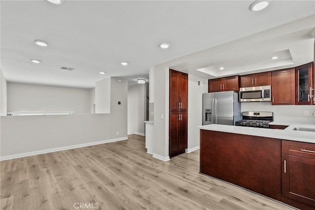 17910 River Cir Unit 5, Canyon Country, CA 91387 - kitchen featuring appliances with stainless steel finishes, light wood-type flooring, recessed lighting, a tray ceiling, and light countertops
