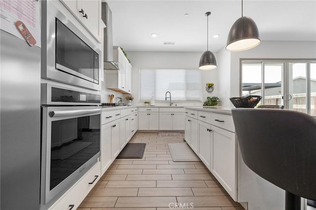1938 N Frontier St, Hanford, CA 93230 - kitchen with stainless steel appliances, wall chimney range hood, light countertops, plenty of natural light, and recessed lighting