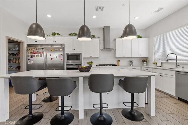 1938 N Frontier St, Hanford, CA 93230 - kitchen featuring built in appliances, wall chimney exhaust hood, light countertops, white cabinetry, and decorative backsplash